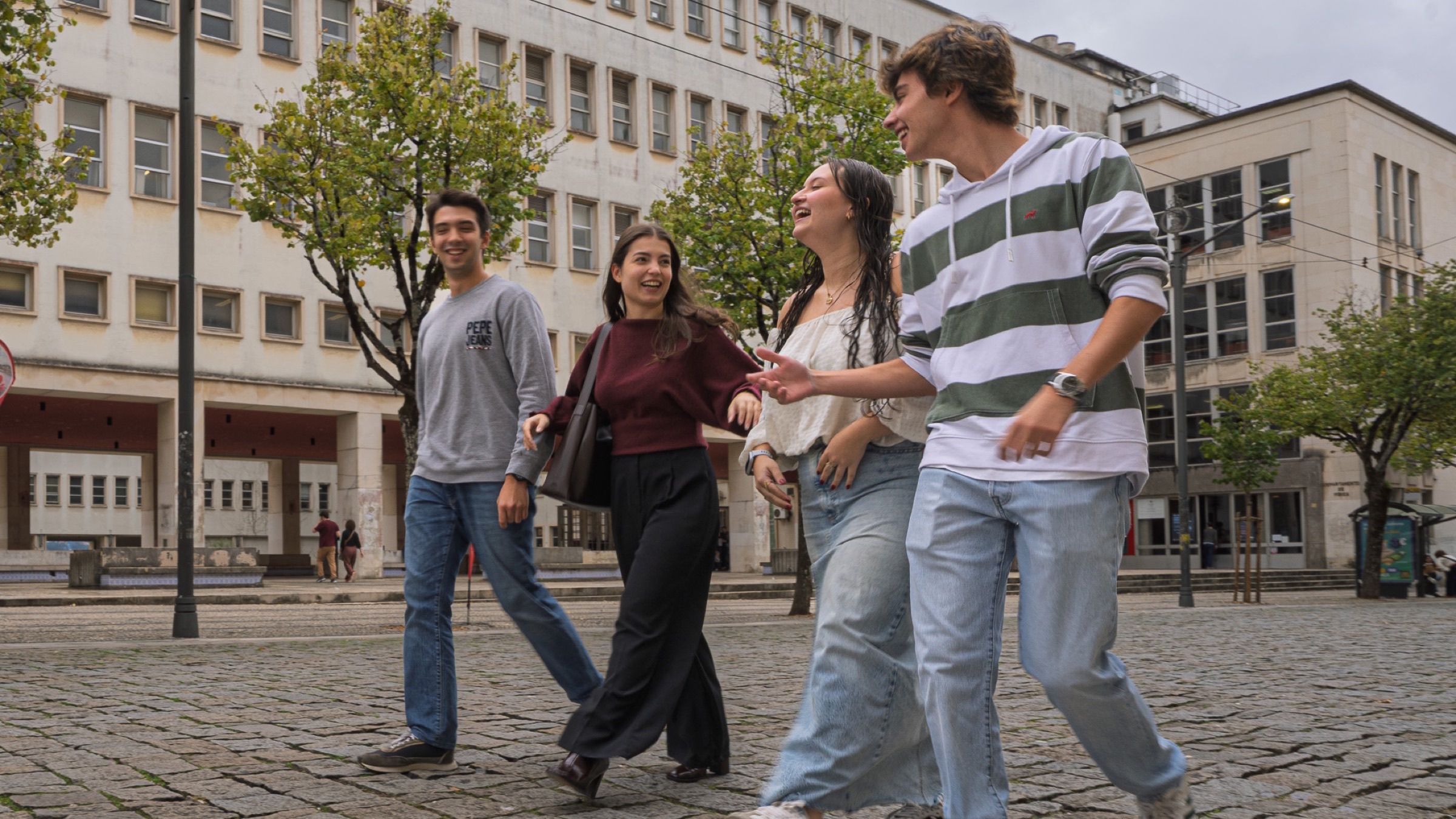 School students walking together across the university courtyard.