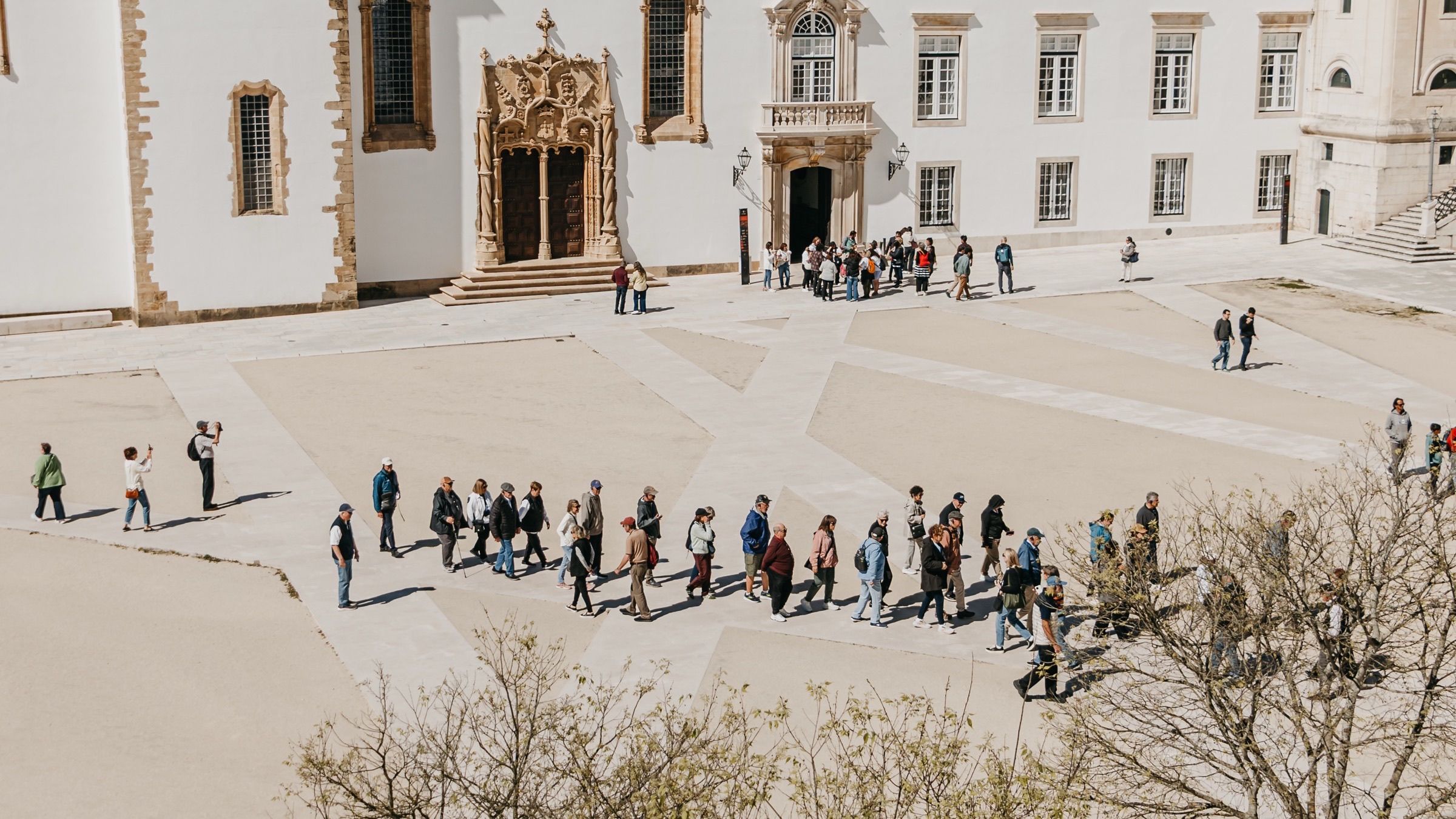 A guided group gathered in the Paço das Escolas courtyard.