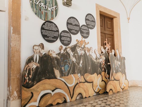 Cut-out figures of caped students mounted along a wall of the Academic Museum.