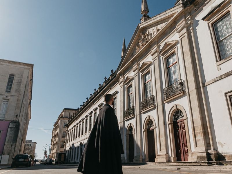 A caped student crossing the courtyard beside the Science Museum.