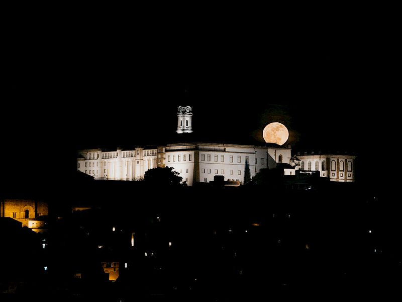 The supermoon rising behind the floodlit University of Coimbra at night. © UC | Felippe Vaz