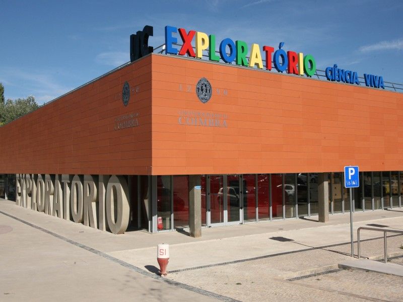 A child's hands on an interactive science exhibit at UC Exploratório.